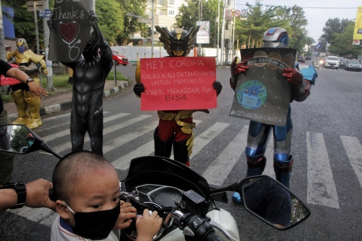 super hero di depan jalan sambil memegang pamplet