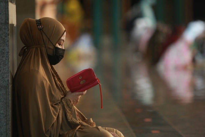 Salah seorang jamaah wanita sedang fokus mengaji