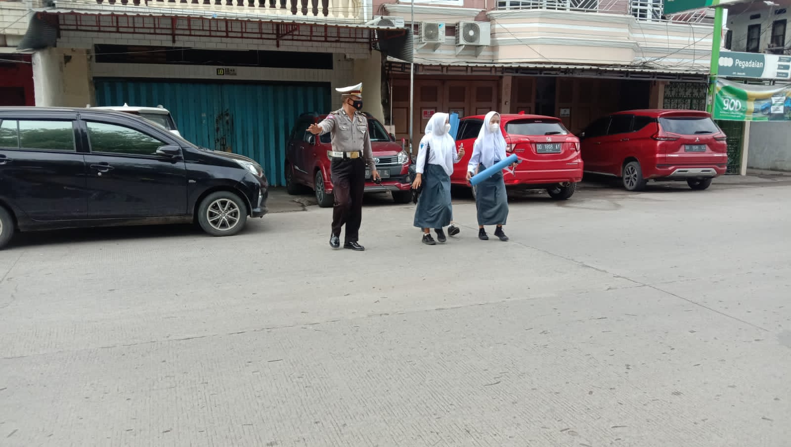 Unit Lantas Polsek Ujung Tanah Bantu Anak Sekolah Menyebrang Jalan