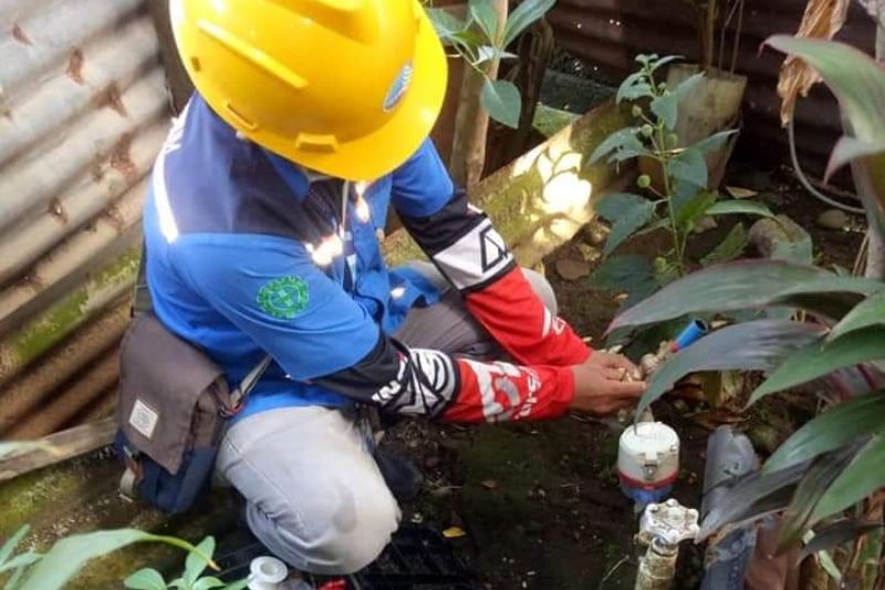 Tampak kantor PDAM Makassar dan petugas yang sedang memeriksa meteran pelanggan di perumahan