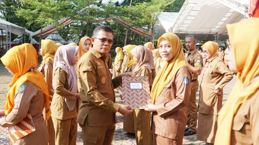 IST PIAGAM -- Pj Sekkab Gowa Abd Karim Dania menyerahkan piagam penghargaan kepada puluhan nakes berprestasi dalam pengelolaan program kesehatan. 