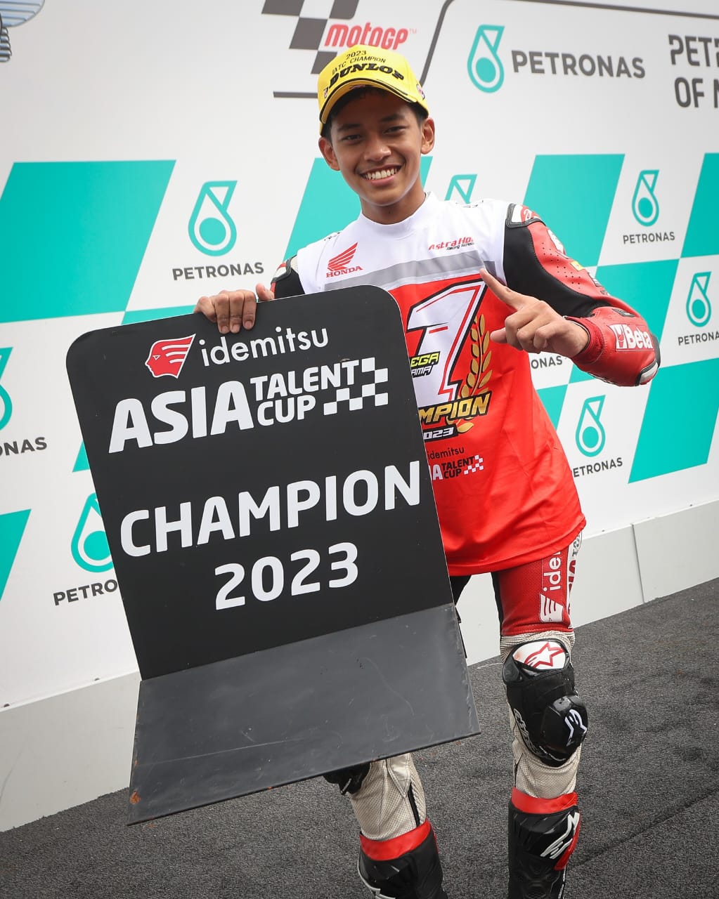 GELAR JUARA -- Veda Ega Pratama tersenyum bahagia setelah menjuarai race kedua seri kelima sekaligus berhasil mengunci gelar juara Idemitsu Asia Talent Cup musim 2023. 