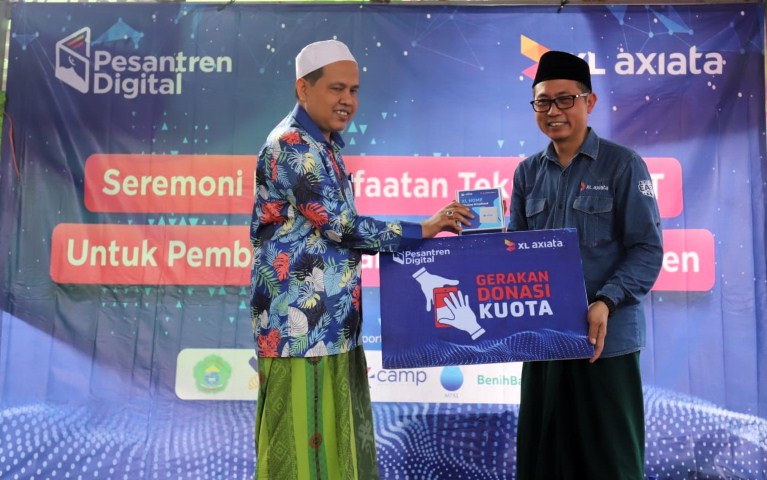 DONASI -- Group Head XL Axiata East Region, Dodik Ariyanto (kanan) menyerahkan donasi 'Gerakan Donasi Kuota' berupa Router dan Paket Internet selama setahun kepada Ketua Yayasan Nurul Himam Assaidi, RKH. Muhammad Gufron di acara implementasi pemanfaatan solusi IoT untuk budidaya maggot di Ponpes Miftahul Ulum Sekar Anyar.