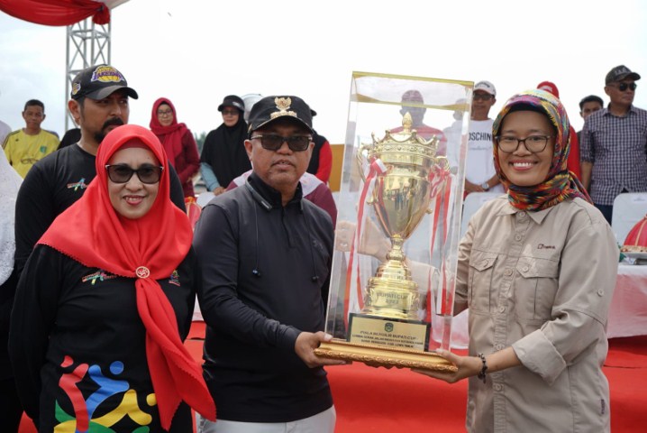 BUKA -- Bupati Luwu Timur, H Budiman menyerahkan piala bergilir usai membuka Lomba Gerak Jalan Indah dan Ketangkasan Baris Berbaris Tingkat SMA se Kabupaten Luwu Timur yang diawali dengan pemukulan gong di Anjungan Sungai Malili, Minggu (12/11).