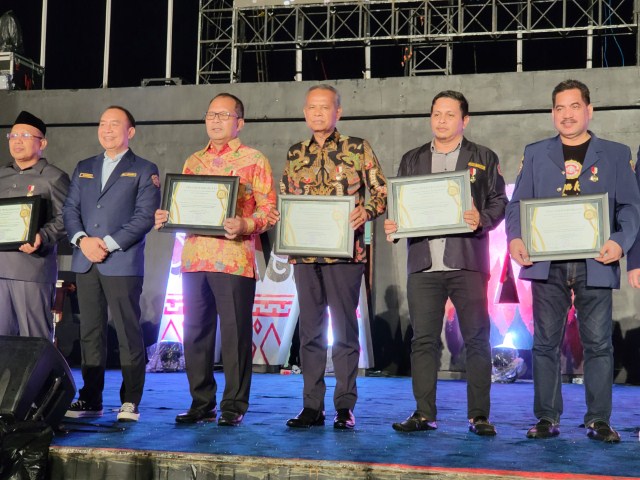 PENGHARGAAN -- Bupati Sidrap H Dollah Mando diwakili Sekab H Basra menerima penghargaan tertinggi Satya Lencana Dharma Aditya Karya Mahatva Yodha Utama (AKMYU) pada puncak acara Bulan Bakti Nasional Karang Taruna 2023 di Anjungan Pantai Losari, Makassar, Sabtu (25/11).