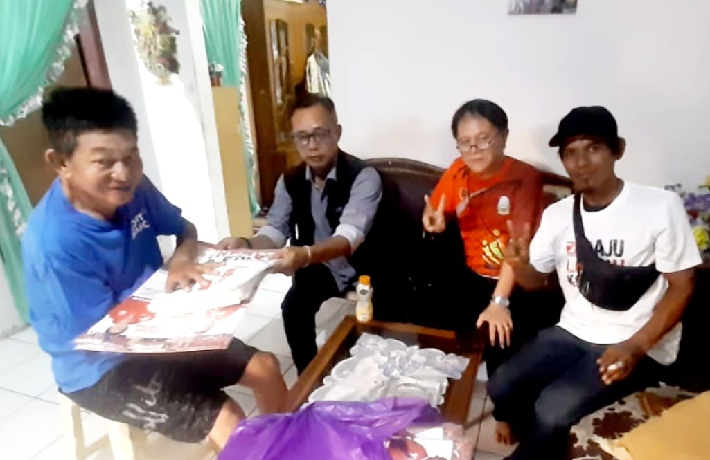 IST BAGI KELENDER--Caleg PSI untuk DPRD Makassar James Leonard Alanus Wehantouw membagikan baju kaos dan kalender kepada warga.