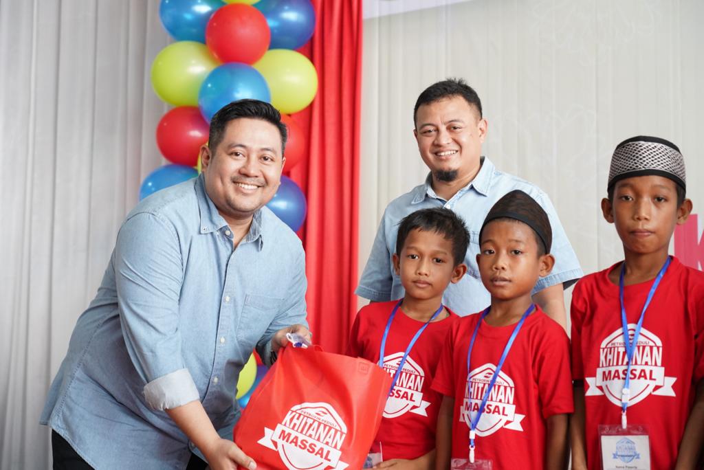 BINGKISAN -- Manager Corporate Communication & Relations EPN, Putiarsa Bagus Wibowo, menyerahkan bingkisan kepada anak-anak peserta khitanan massal gratis di Kota Makassar.