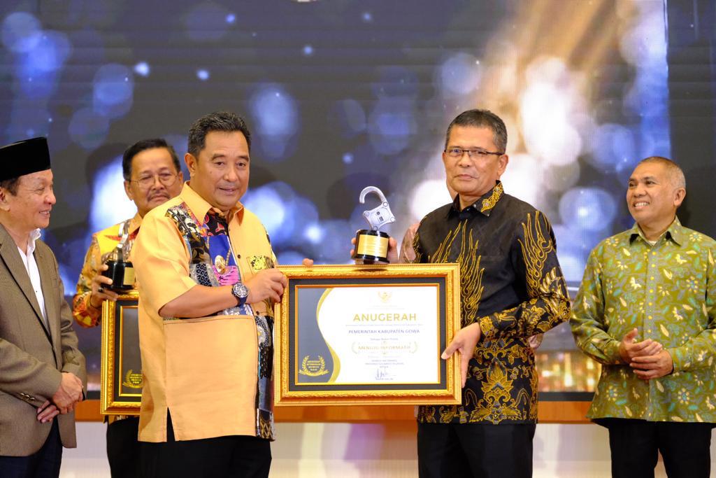 IST MENUJU INFORMATIF -- Pj Sekkab Gowa, Abd Karim Dania saat menerima penghargaan predikat 'Menuju Informatif' 2023 dari Pj Gubernur Sulsel, Bahtiar Baharuddin. 