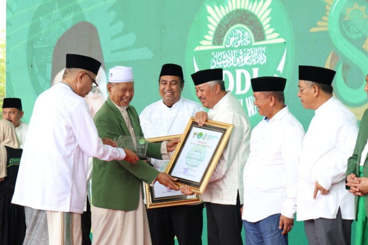 PENGHARGAAN -- Bupati Pinrang Irwan Hamid menerima penghormatan dan penghargaan dari Pengurus Besar (PB) Darud Da'wah Wal Irsyad (DDI) Sulsel di Lapangan Karebosi Makassar, Minggu (17/12). 