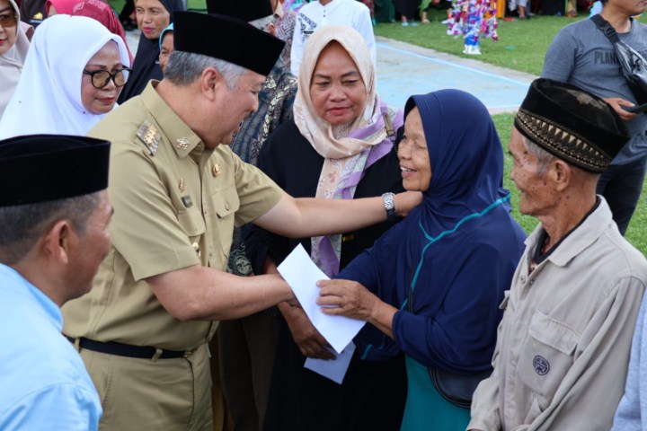 SANTUNAN -- Bupati Pinrang Irwan Hamid menyerahkan santunan kepada kaum dhuafa disela-sela peringatan Maulid Nabi Muhammad SAW di Lapangan Massapaila Desa Rajang Kecamatan Lembang, Selasa (5/12)