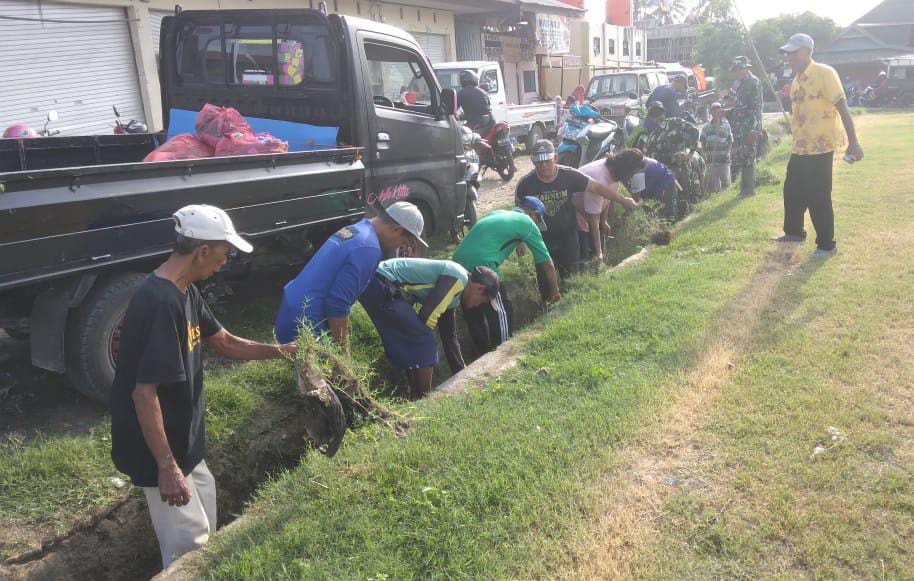 KERJA BAKTI -- Personel Babinsa Koramil 1423-02/Marioriawa melaksanakan karya bakti pembersihan lingkungan sepanjang selokan di Pasar Sentral Batu Batu Kelurahan Manorangsalo Kecamatan Marioriawa Kabupaten Soppeng. Kamis (21/12). 