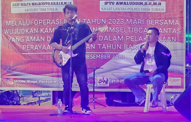 BERNYANYI -- Kapolres Tana Toraja AKBP Malpa Malacoppo bernyanyi dan menghibur masyarakat di live music simponi natal di Plaza Kolam Makale, Selasa (26/12). 