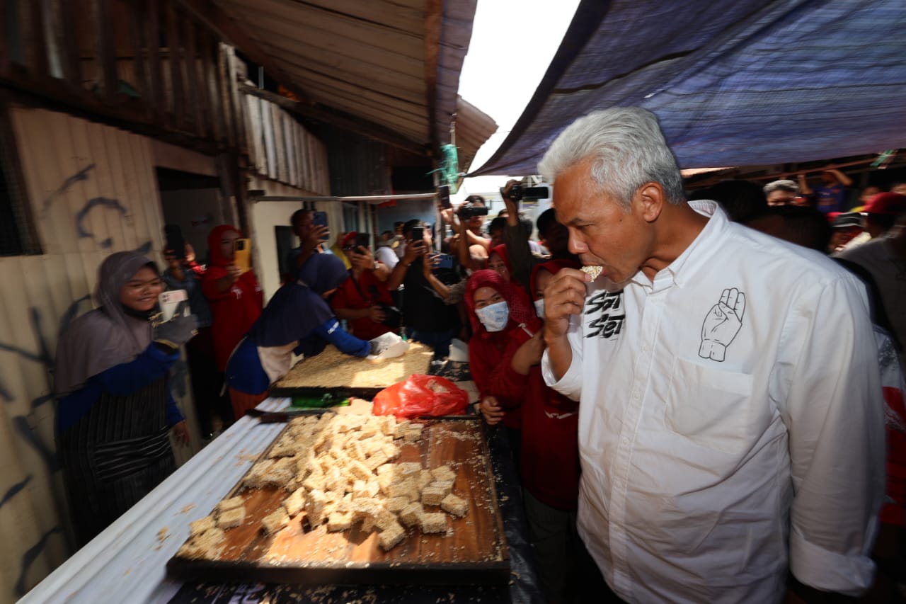 IST MENCICIPI--Capres nomor urut 3 Ganjar Pranowo berdialog dengan pedagang sambil mencicipi kue lokal yang dijual. (kanan). Sementara jubir TPD Ganjar-Mahfud Sulsel Muhammad Iqbal Arifin memberikan keterangan )