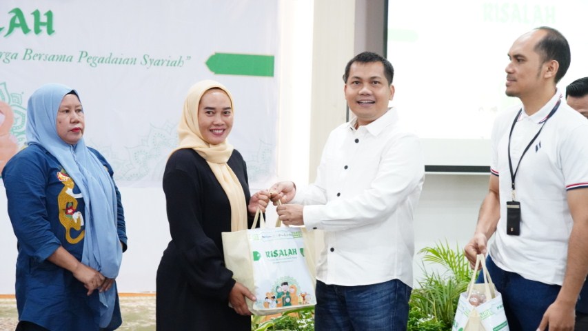 BINGKISAN -- Deputy Operasional PT Pegadaian Kanwil VI Makassar, Jainuddin mewakili Pemimpin Wilayah Pegadaian didampingi Kepala Departemen Bussiness Support, Iwan Darmawan, menyerahkan bingkisan kepada perwakilan peserta.
