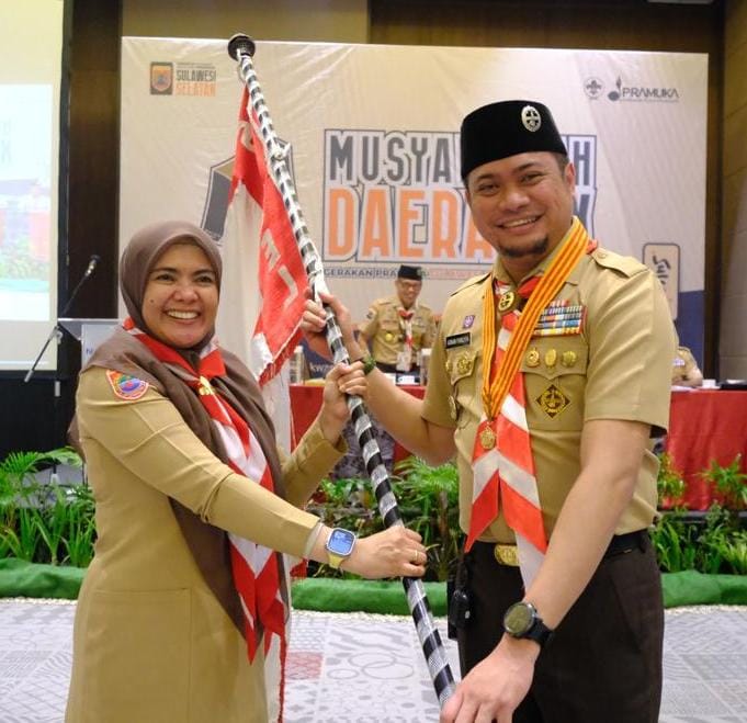 IST KWARDA -- Bupati Gowa, Adnan Purichta Ichsan dan Wabup Maros, Hj Suhartina Bohari memegang bendera setelah keduanya terpilih sebagai ketua dan wakil ketua Kwarda Sulsel.