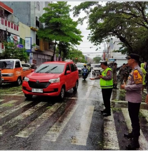 PENGATURAN -- Personel kepolisian Unit Lalulintas Polsek Bontoala melakukan pengamanan dan pengaturan arus lalulintas di lokasi pohon tumbang Jalan Masjid Raya.