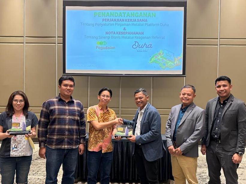 KERJA SAMA -- Chief of Transformation Office PT Pegadaian, Mulyono (tiga dari kanan) dan Director PT Duha Madani Syariah, Hot Asi (tiga dari kiri) bertukar cinderamata usai melakukan penandatanganan nota kesepahaman terkait sinergi bisnis,