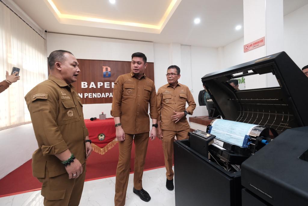 IST PANTAU -- Bupati Gowa, Adnan Purichta Ichsan didampingi Pj Sekretaris Kabupaten Gowa, Abd Karim Dania, saat memantau pencetakan surat PBB P2 tahun 2024 di kantor Bapenda Gowa. 