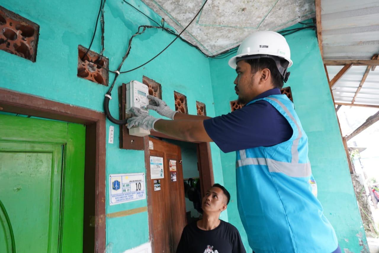PEMASANGAN KWH -- Salah seorang mitra PLN sedang melakukan pemasangan kwh meter di rumah salah seorang pelanggan.