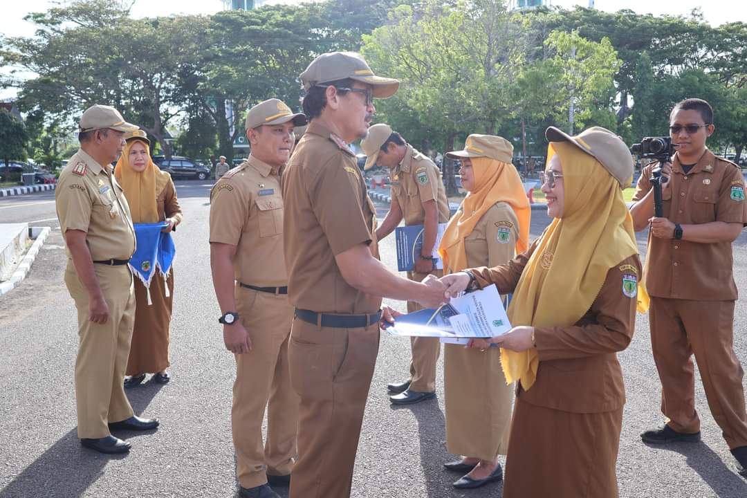 SERAHKAN SK -- Sekkab Pinrang A Calo Kerrang mewakili Bupati Pinrang menyerahkan SK kenaikan pangkat secara simbolis kepada PNSD periode Februari 2024 di Halaman Kantor Bupati Pinrang, Senin (29/1). 