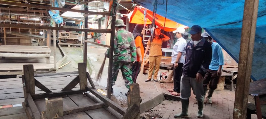 BERSIHKAN PASAR -- Karya bakti TNI Koramil Mengkendek membersihkan Pasar Tradisional Salubarani bersama warga setempat, Senimn (22/1)