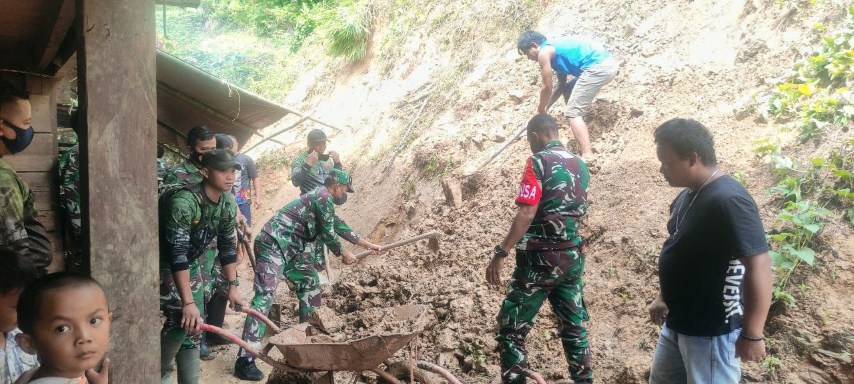 GOTONG ROYONG -- Koramil 05 Sanggalangi bergotong royong bersama warga melakukan pembersihan tanah longsor yang menimpa rumah warga, Selasa (2/1).