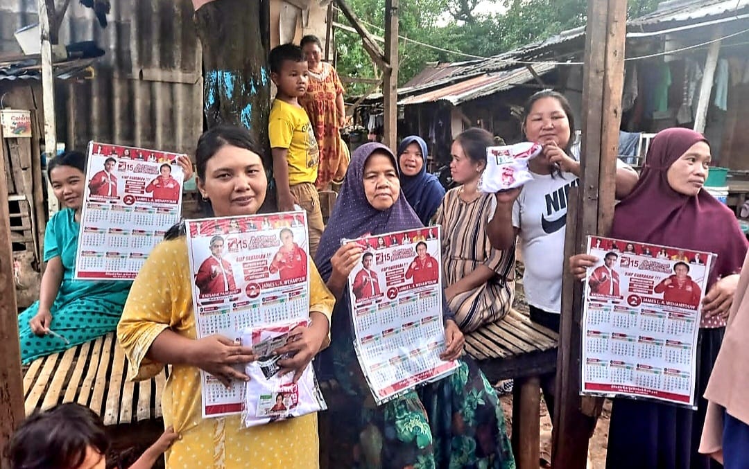 IST MEMBAGIKAN--Tim dan relawan Caleg PSI James Wehantouw membagikan kalender dan baju kaos kepada masyarakat 