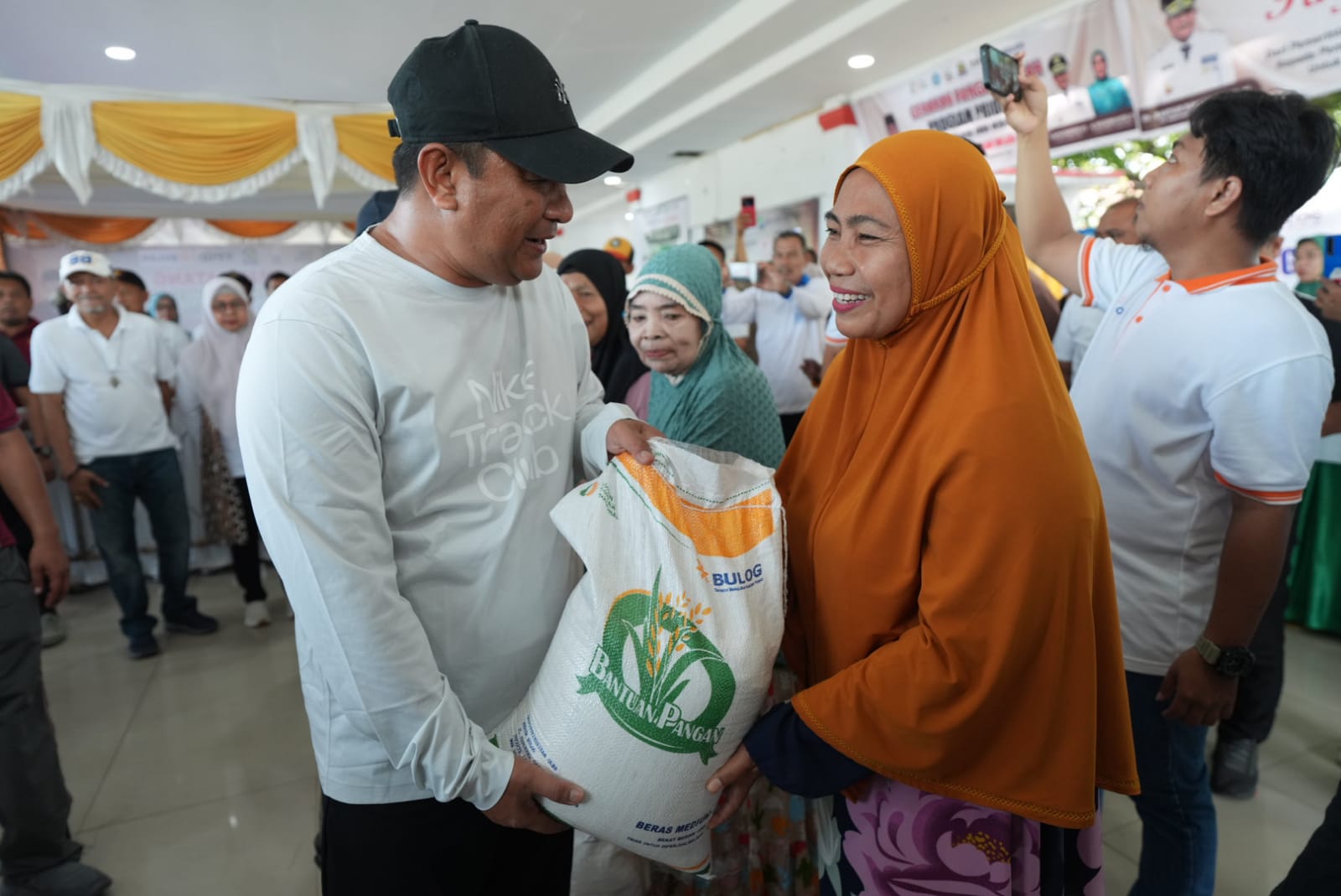 BANTUAN PANGAN -- Pj Gubernur Sulsel, Bahtiar Baharuddin didampingi Pj Bupati Takalar, Junaedi Bakri menyerahkan bantuan pangan kepada warga 