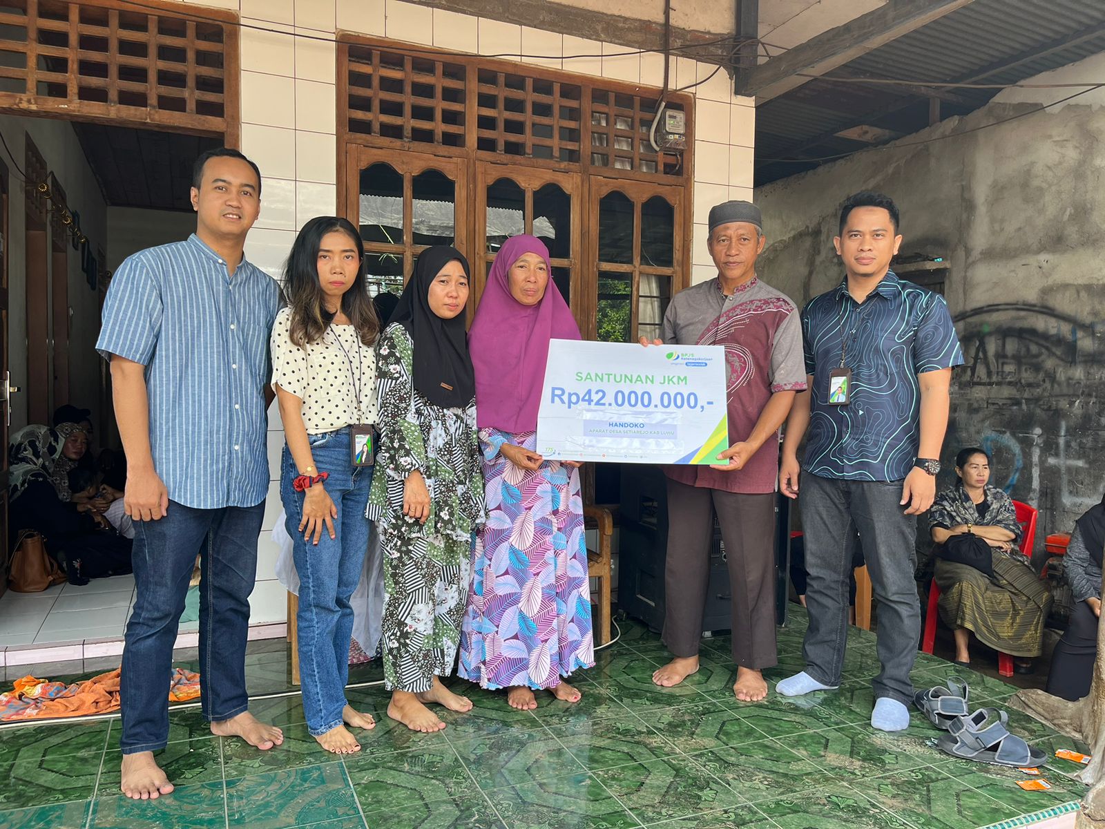 SANTUNAN JKM -- Kepala Bidang Pengendalian Operasional BPJamsostek Cabang Palopo, Adi Bagus Maulana Abdullah, didampingi tim, menyerahkan santunan JKM kepada Hariati, isteri sekaligus ahli waris almarhum Handoko, Kades Setiarejo, Kabupaten Luwu yang meninggal dunia pada 22 Februari 2024 karena sakit.
