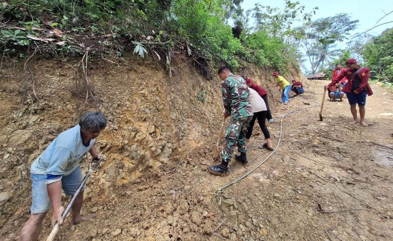 GOTONG ROYONG -- Babinsa Koramil Mengkendek menggelar Kaya Bakti dan bergotong royong dengan warga setempat melakukan pemasangan gorong-gorong di jalan poros Lembang Randanan dalam 