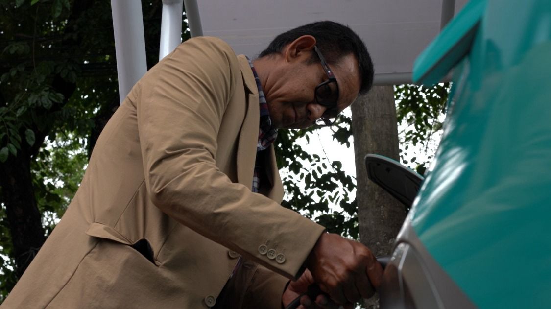 PENGISIAN -- GM PLN UID Sulselrabar, Moch. Andy Adchaminoerdin tengah melakukan pengisian daya mobil listrik.