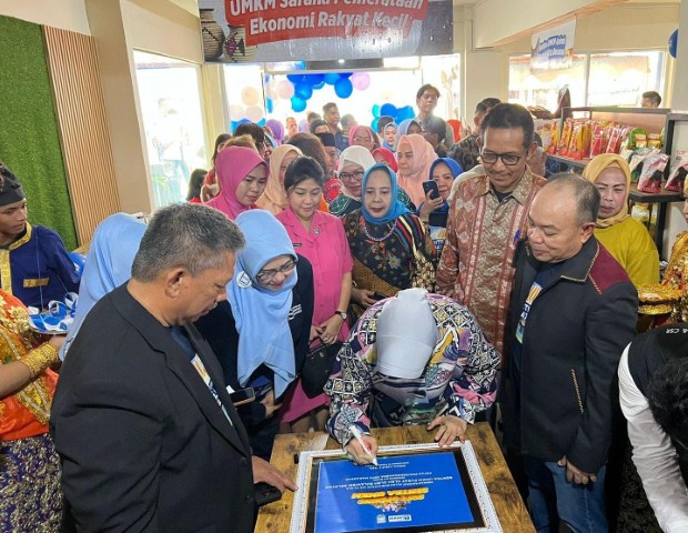 PERESMIAN -- General Manager PLN UID Sulselrabar, Moch. Andy Adchaminoerdin (berkacamata) bersama Ketua Apindo Sulsel, Suhardi, menyaksikan penandatanganan prasasti oleh ketua Dekranasda Kota Makassar sebagai pertanda peresmian Sentra UMKM Pusat Ole-Ole Sulsel.