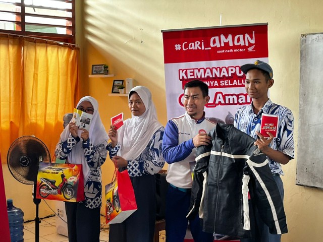 SAFETY RIDING -- Instruktur Safety Riding Asmo Sulsel, Wanny memberikan cinderamata kepada sejumlah siswa SMAN 19 Makassar di sela melaksanakan edukasi Safety Riding di sekolah tersebut
