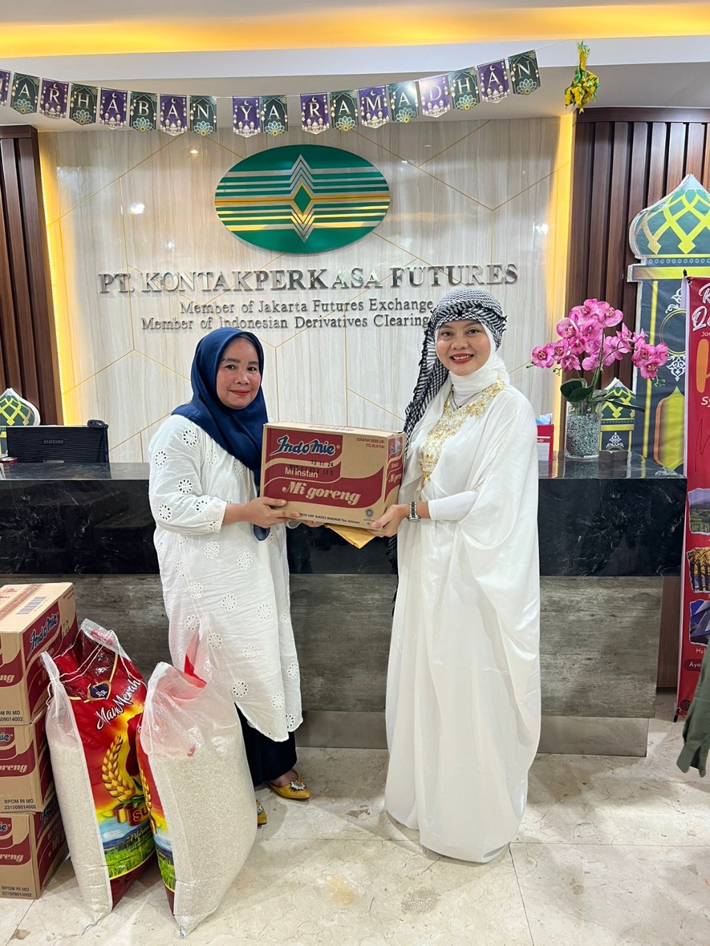 SEMBAKO -- Branch Manager PT KPF Makassar, Sri Mulyanti (kanan) menyerahkan paket Sembako kepada pendamping anak Panti Asuhan Tobalu.