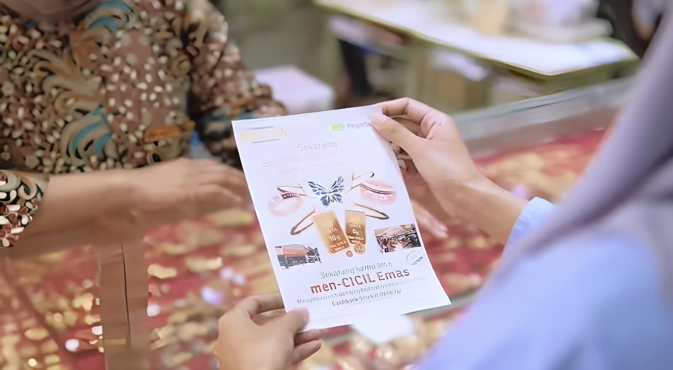 PENAWARAN MENARIK -- Seorang konsumen sedang membaca flyer salah satu penawaran menarik yang kini ditawarkan Pegadaian Kanwil Makassar.