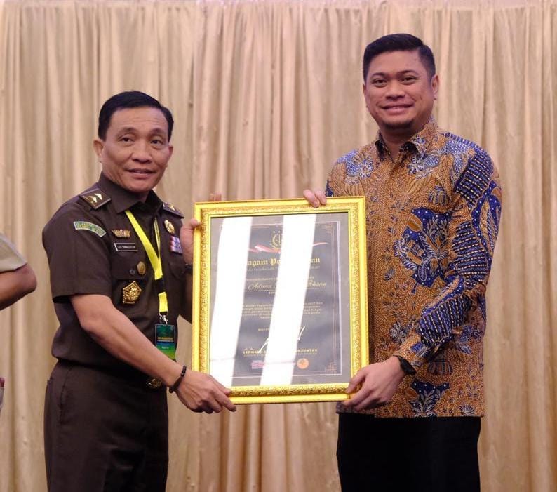 IST PENGHARGAAN -- Kepala Kejati Sulsel, Leonard Eben Ezer Simanjuntak, menyerahkan penghargaan role model kepada Bupati Gowa, Adnan Purichta Ichsan. 