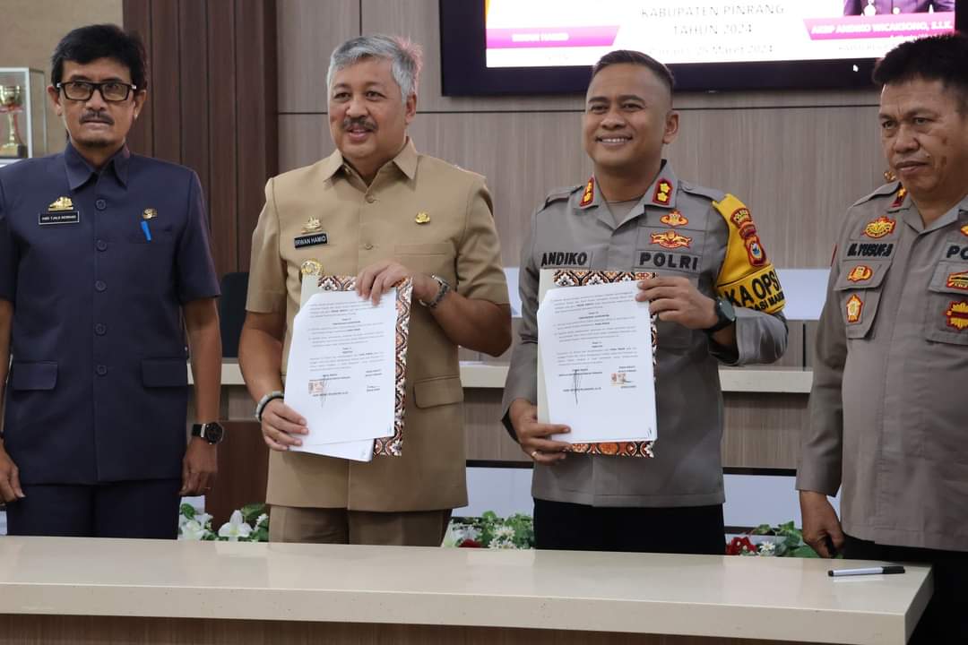 TEKEN -- Bupati Pinrang Irwan Hamid bersama Kapolres Pinrang AKBP Andiko Wicaksono menandatangani Naskah Perjanjian Hibah Daerah (NPHD) di Ruang rapat Bupati Pinrang, Senin (25/3).