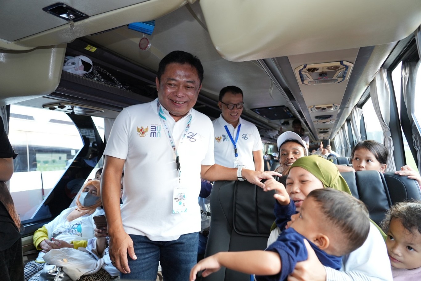 BERINTERAKSI -- Direktur Utama Telkom, Ririek Adriansyah (depan) didampingi Direktur Utama Telkomsel, Nugroho (belakang) saat berinteraksi dengan pemudik di bus Telkom dalam kegiatan Mudik Asyik Bersama BUMN 2024 di kawasan pemberangkatan bus Monumen Nasional Jakarta, Jumat (5/4).