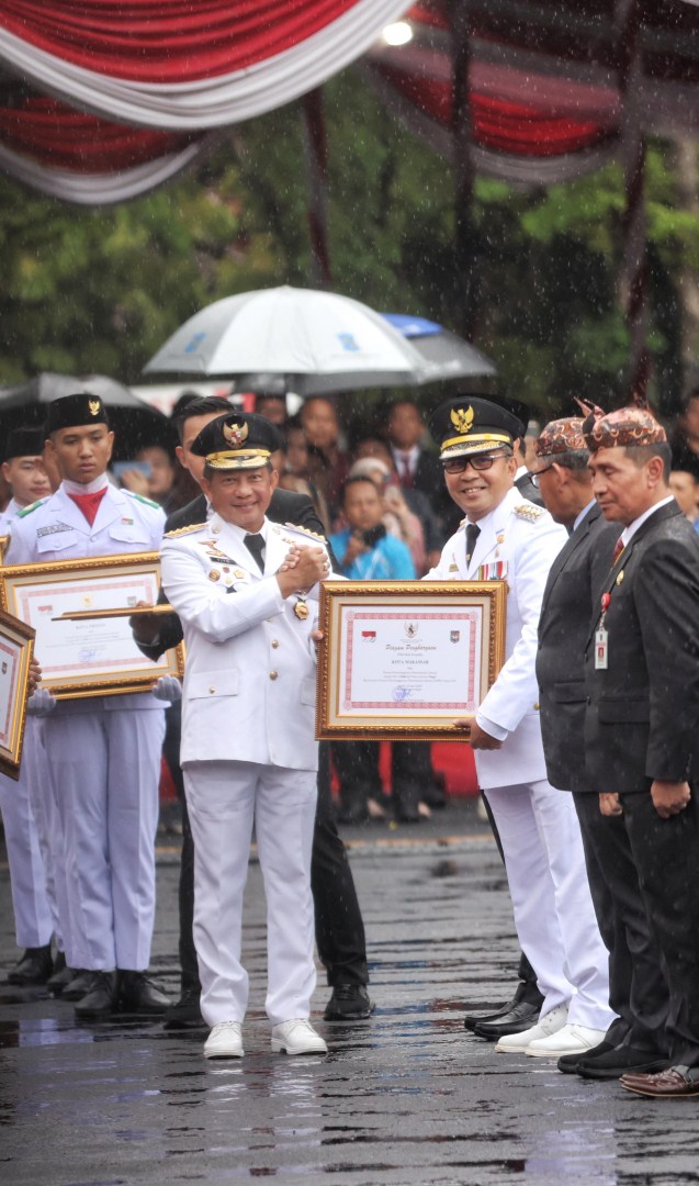 ist PENGHARGAAN--Mendagri Tito Karnavian menyerahkan penghargaan ke Wali Kota Makassar Moh Ramdhan Pomanto pada Puncak Peringatan OTDA XXVIII, di Halaman Balai Kota Surabaya, Kamis (25/4).