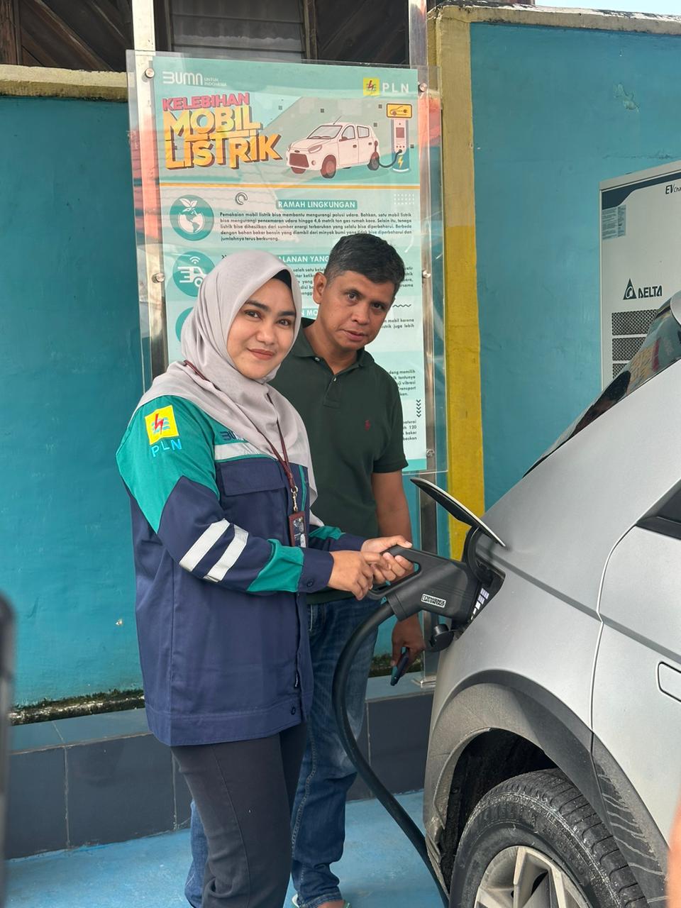 PENGISIAN -- Manager PLN UP3 Palopo, Rathy Shinta Utami (kiri) tengah mendampingi pemilik mobil listrik, Azis saat melakukan pengisian daya di SPKLU PLN UP3 Palopo.