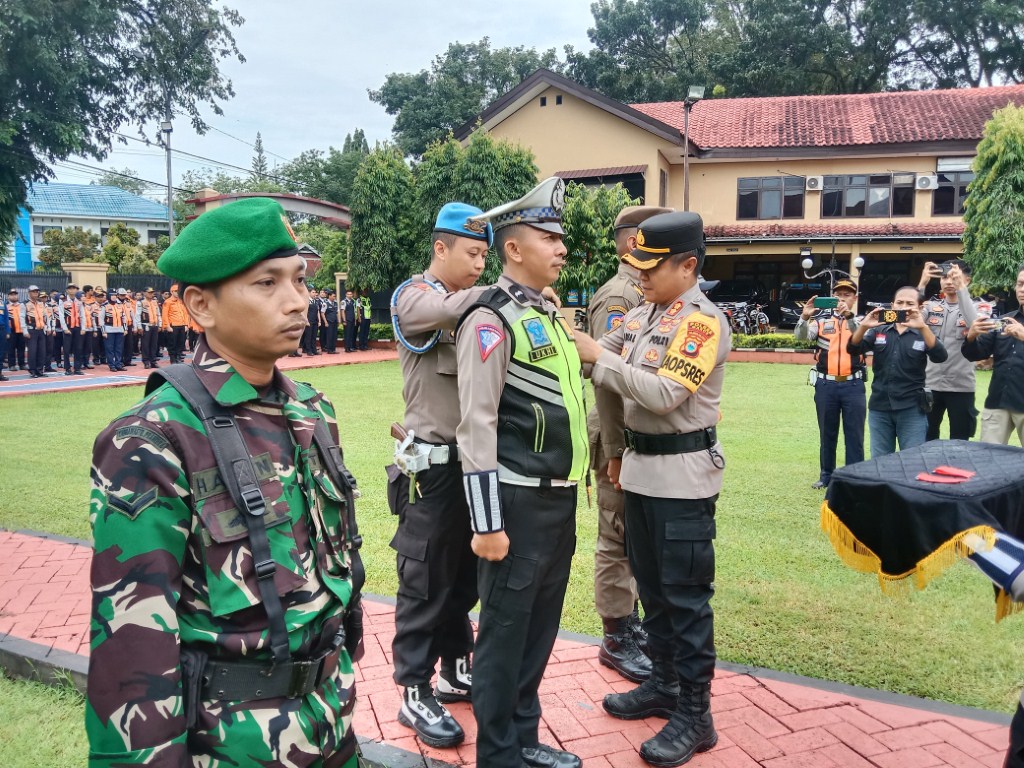 APEL -- Kapolres Maros, AKBP Awaluddin Amin menyematkan tanda kepada salah seorang personel kepolisian dalam apel gelar pasukan Operasi Ketupat 2024. Operasi ini melibatkan segenap unsur pengamanan termasuk TNI, Satpol PP, dan unsur lainnya.