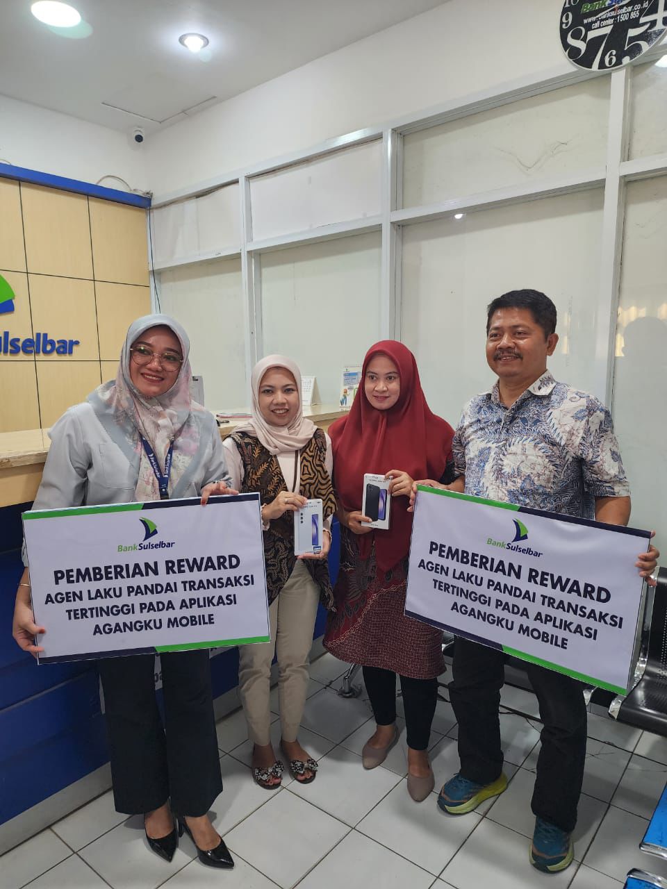 HADIAH -- Pimpinan Bank Sulselbar Bulukumba Andi Yudiarti melakukan kunjungan sekaligus menyerahkan hadiah smartphone kepada dua agen Bank terbaik se Sulsel yang diraih dua orang agen Bank asal Bulukumba yaitu Susanti dan Herawati baru-baru ini 