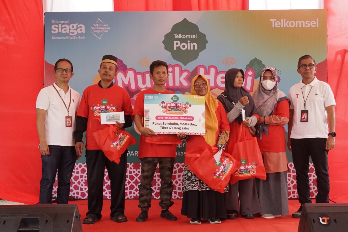 MUDIK HEPI -- Vice President Area Network Operations Telkomsel Pamasuka, Andrias Indra dan Vice President Consumer Business Telkomsel Area Pamasuka (tengah), foto bersama peserta Mudik Hepi Telkomsel Poin usai menyerahkan bingkisan secara simbolis sebelum dilakukan pelepasan.