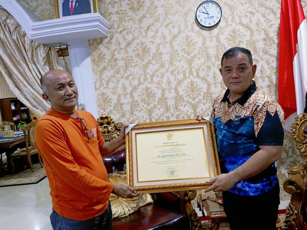 PENGHARGAAN -- Kadis Sosial Sinjai, Andi Muhammad Idnan saat menyerahkan piagam penghargaan yang diberikan kepada Pj Bupati yang diantar Kementerian Sosial RI, melalui Balai Sentra Pangurangi Takalar di Rumah Jabatan Bupati Sinjai, Rabu (17/4)