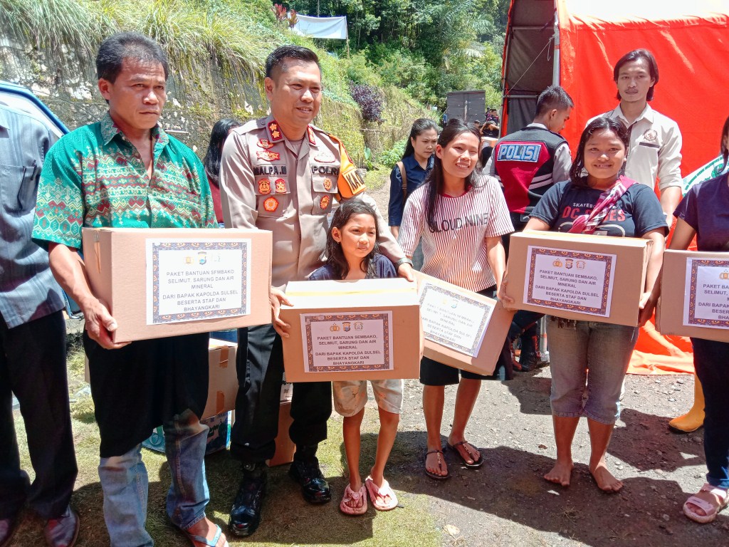 BANTUAN -- Kapolres Tana Toraja AKBP Malpa Malacoppo saat menyerahkan bantuan pangan Kapolda Sulsel di posko bencana Palangka kepada para korban bencana, Kamis (18/4).
