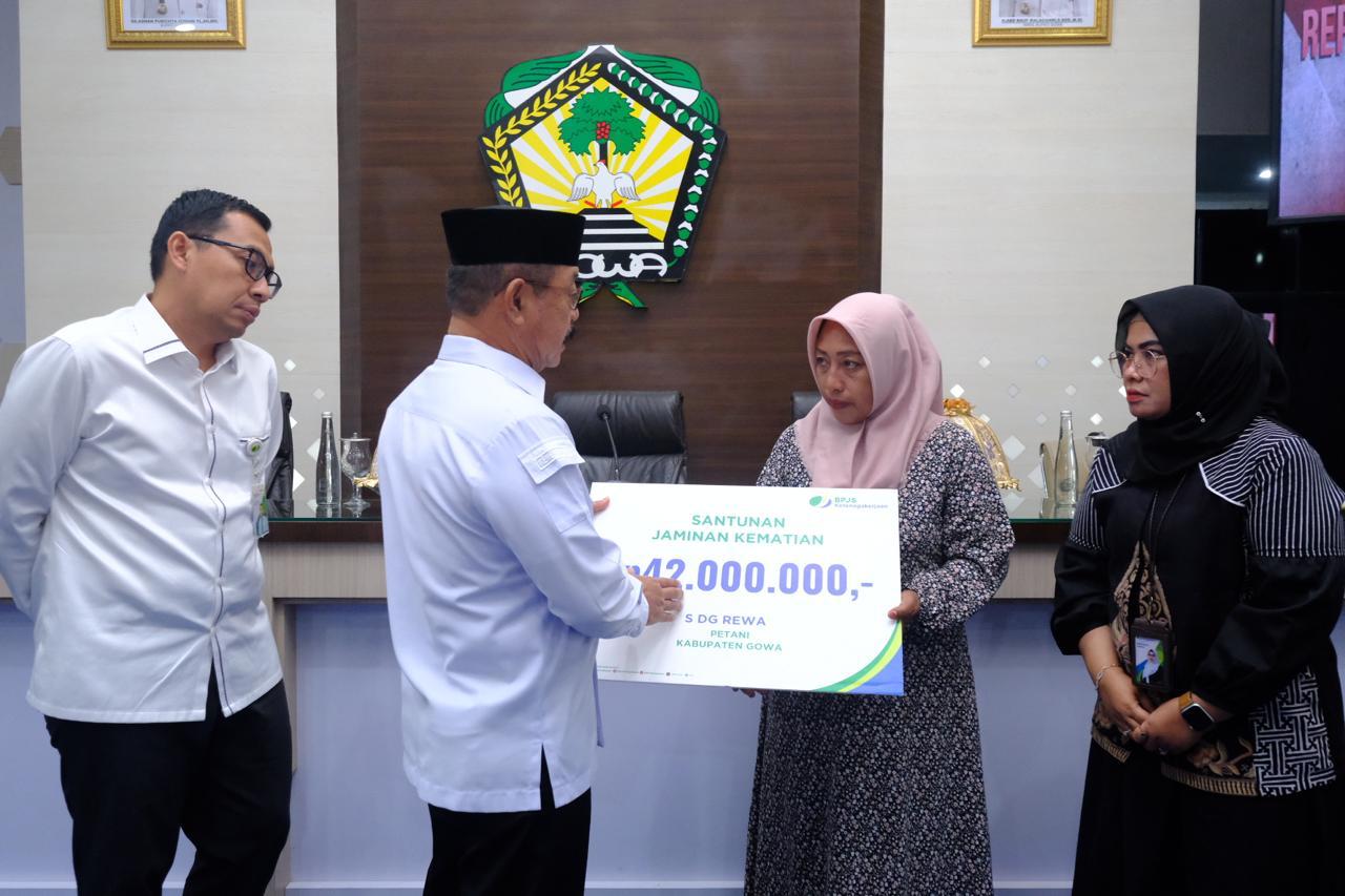 IST JAMINAN -- Wakil Bupati Gowa, Abdul Rauf Malaganni, menyerahkan jaminan perlindungan sosial kepada ahli waris salah seorang pekerja informal di Gowa disaksikan Tim Kajian Sistemik Ombudsman RI. 