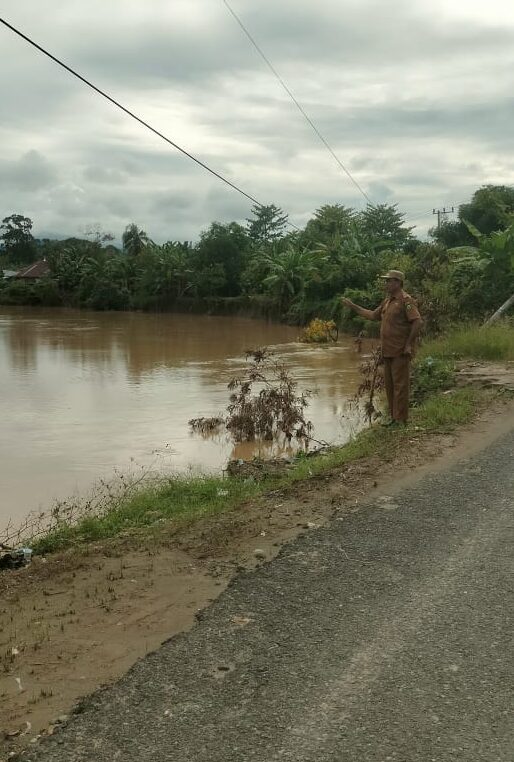 KHAWATIR -- Kades Cimpu Utara H Muhammad Ali menunjukan volume air yang terus bertambah, Kades khawatir bahu jalan yang semakin hari terus terkikis gegara volume arus air sungai yang semakin tinggi. 