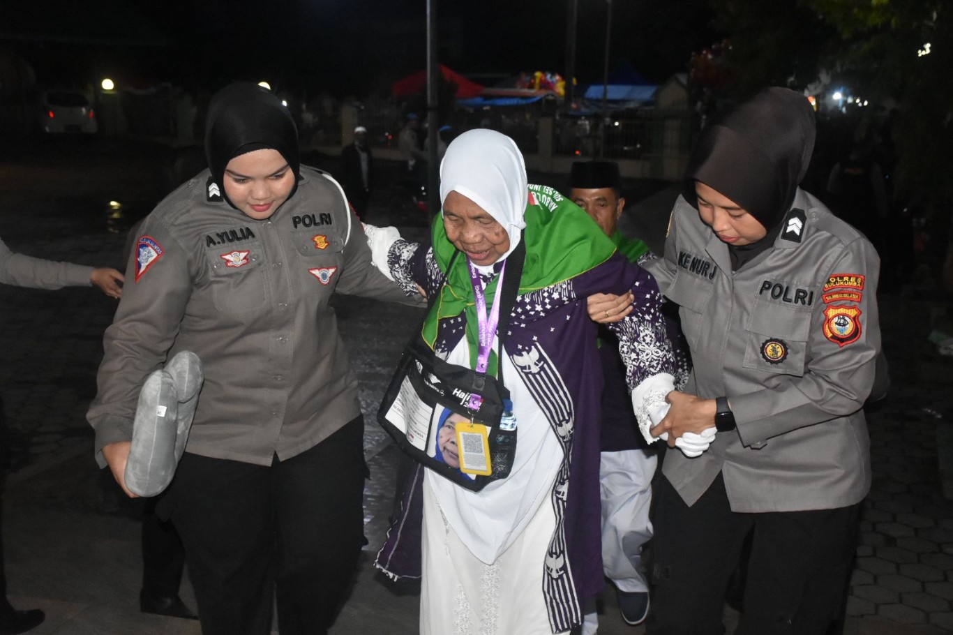 DILEPAS -- Seorang JCH lansia asal Bulukumba dipapah menuju Bus oleh personel Sat Lantas Polres Bulukumba saat diberangkatkan dari Masjid Agung Bulukumba menuju Asrama Haji Sudiang Makassar usai dilepas secara resmi oleh Bupati Bulukumba, Jumat (24/5) dinihari.   