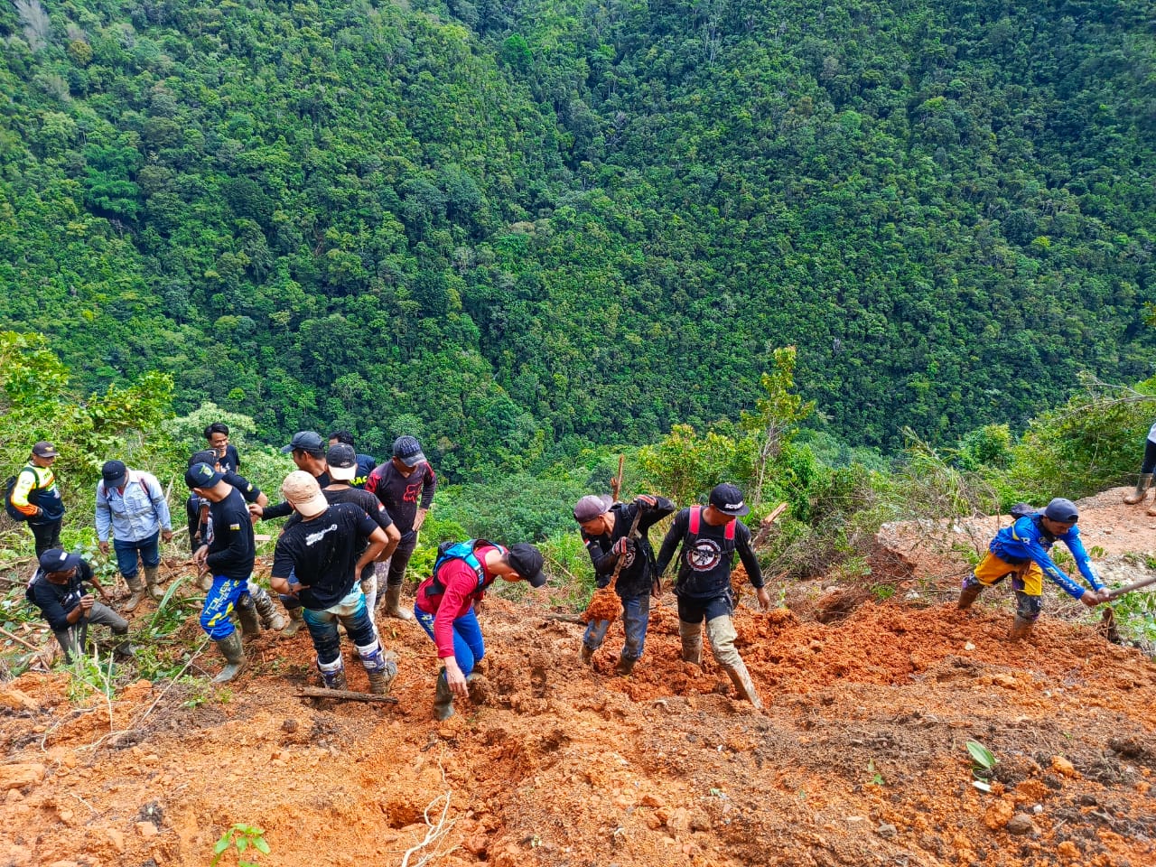 BERSIHKAN -- -- Warga dua dusun di Desa Sawitto, Kecamatan Bungin-Enrekang terisolir dan ketersediaan stok makanan sebanyak 620 warga di dua dusun tersebut yakni Dusun Nating dan Dusun Katabi menipis. Tampak warga dan tim SAR sedang melakukan pembersihan material longsor yang menutupi badan jalan.  