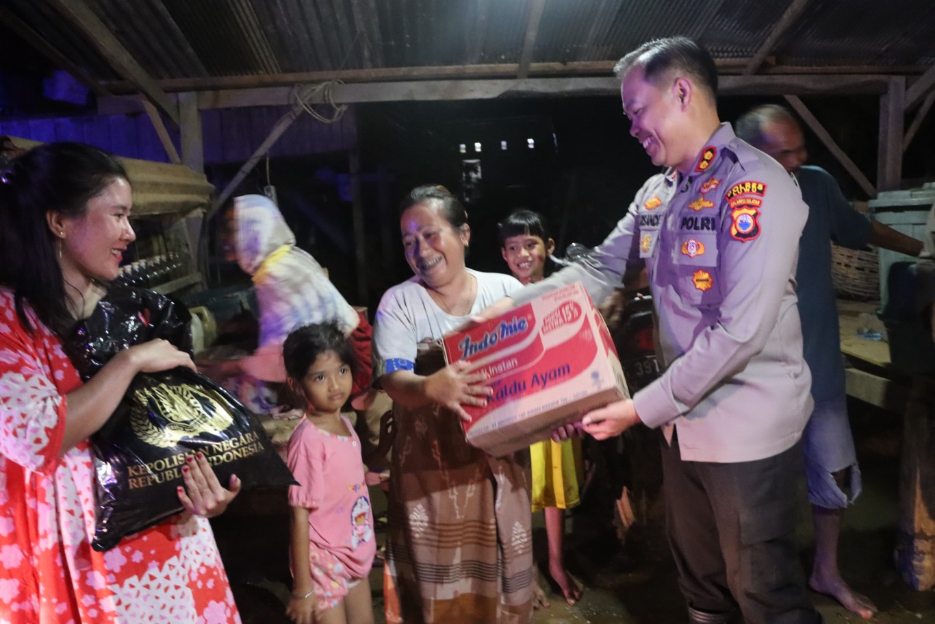 SALURKAN BANTUAN -- Kapolres Luwu AKBP Arisandi saat menyerahkan bantuan sembako kepada warga terdampak banjir dan longsor di lokasi bencana, Senin (7/5).  
